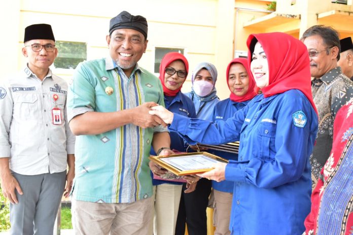 Wali Kota Baubau La Ode Ahmad Monianse didampingi Kepala Disdikbud Baubau La Ode Aswad saat menyerahkan piagam penghargaan kepada salah satu guru. (FOTO ASMADDIN)